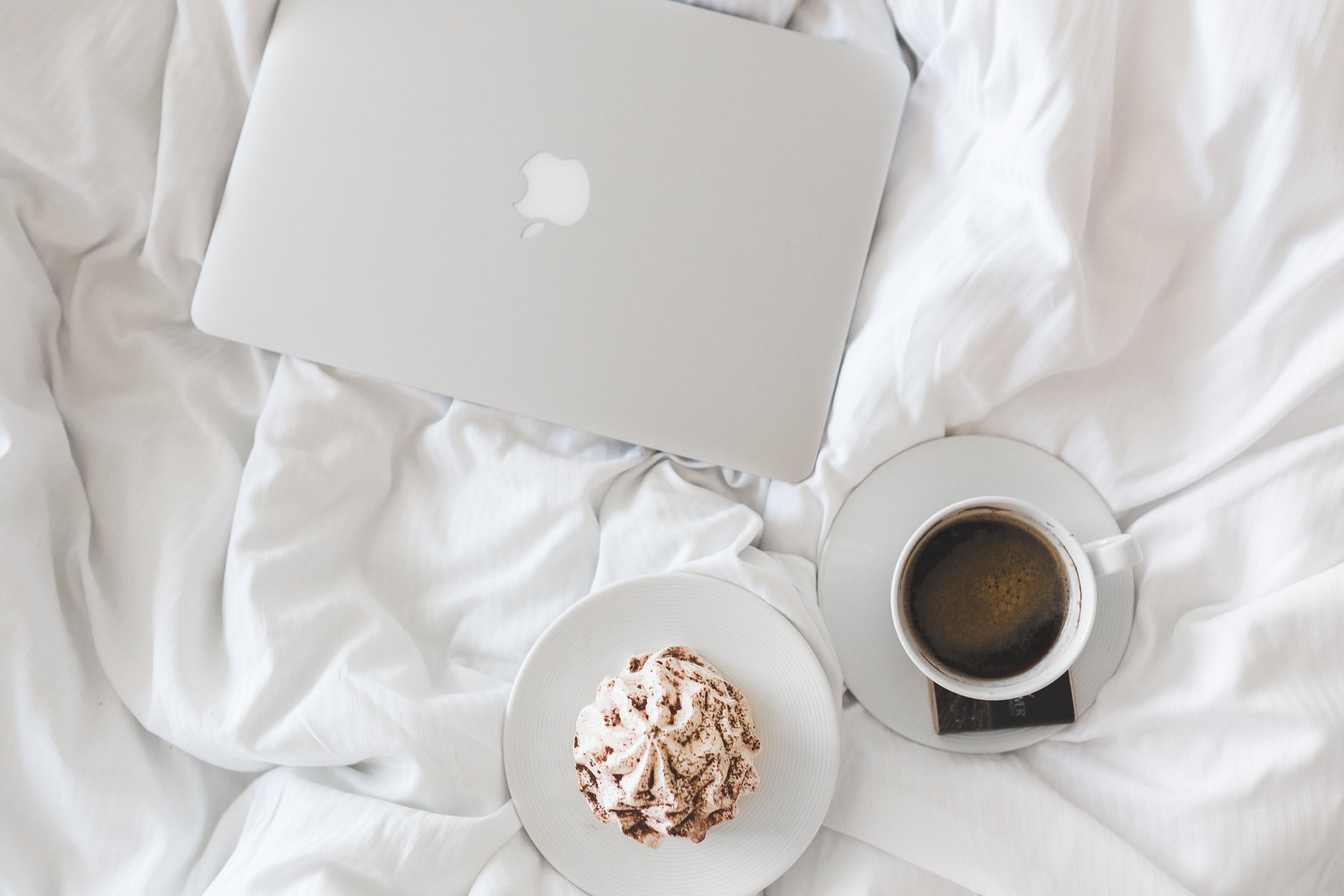 Silver Macbook on White Bed Comforter